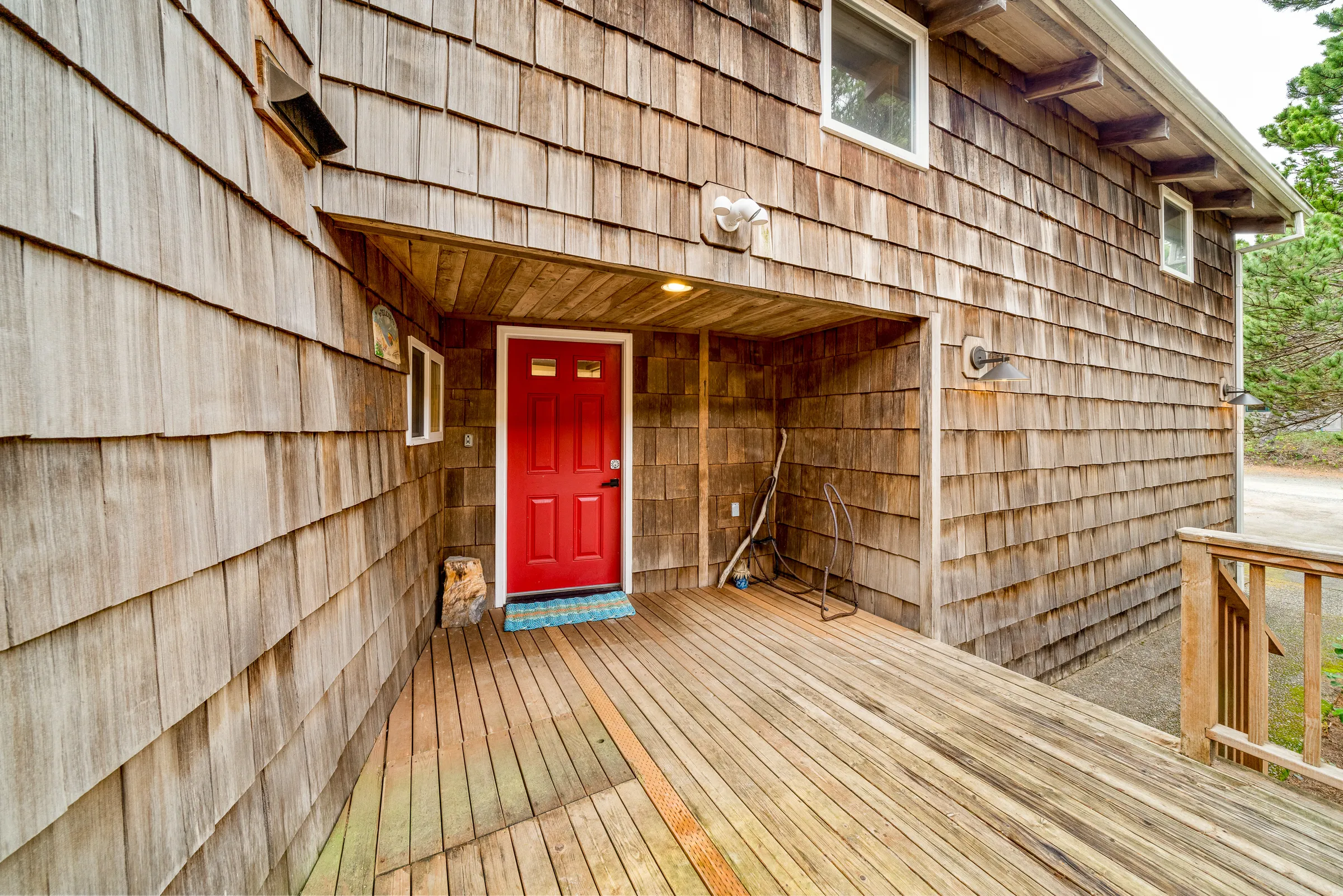 Red front door with cedar shake siding